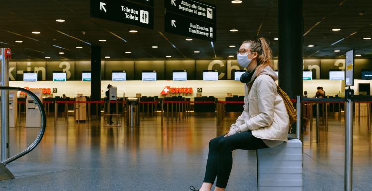 Young woman sat waiting in an airport 