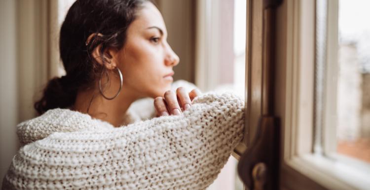 Young woman looking out of a window 