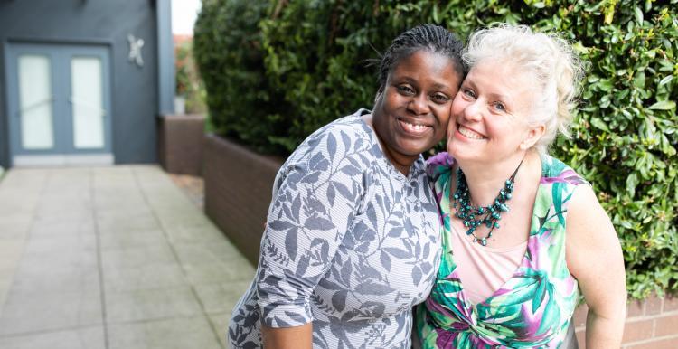 Two people hugging and smiling