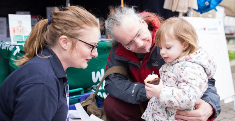 Healthwatch staff member talking to older man with child 