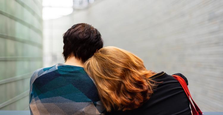 Two young people leaning on each other 