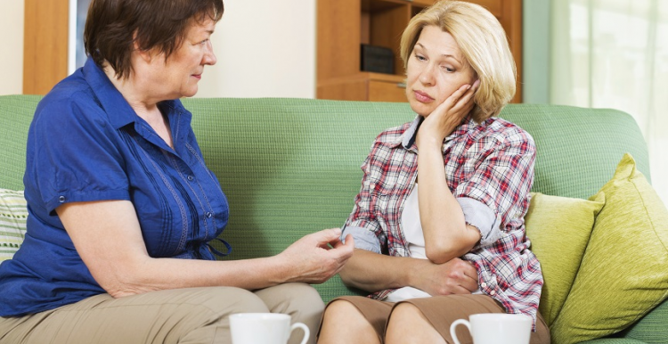 Two women talking on a couch 