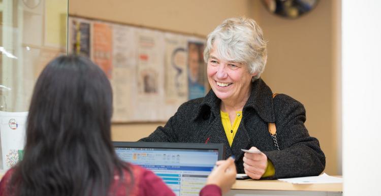 lady at a GP reception desk 