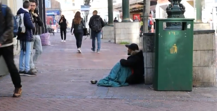 homeless man on a busy street 