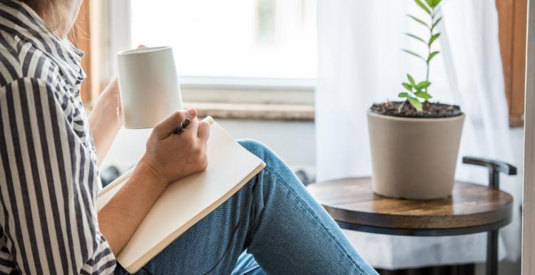 women_sat_witing_in_notebook