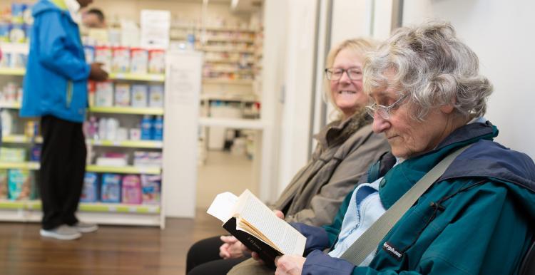 Two people sat in a pharmacy 