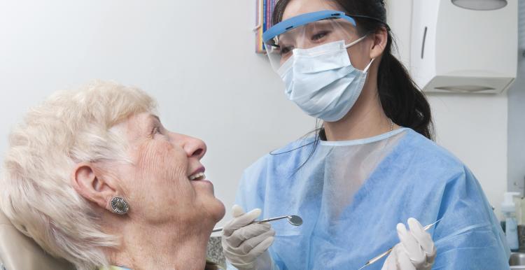 Older lady in a dentist chair smiling at the dentist 