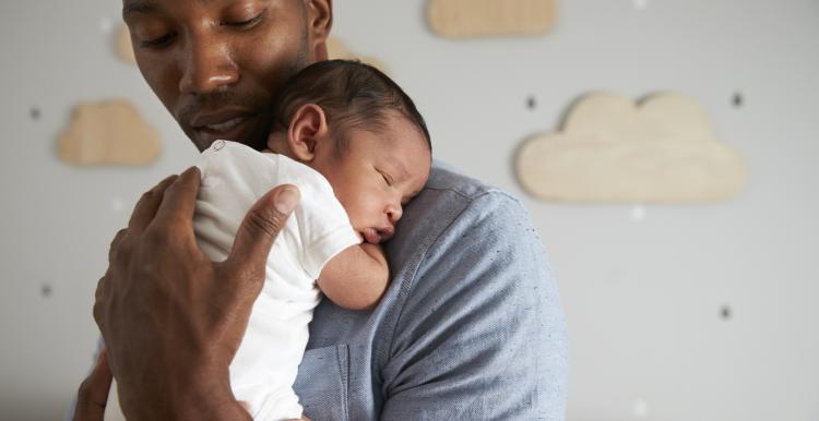Safer-Sleep-Week man holding young baby 
