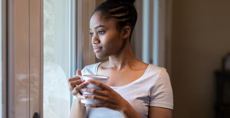 young woman looking out of a window 