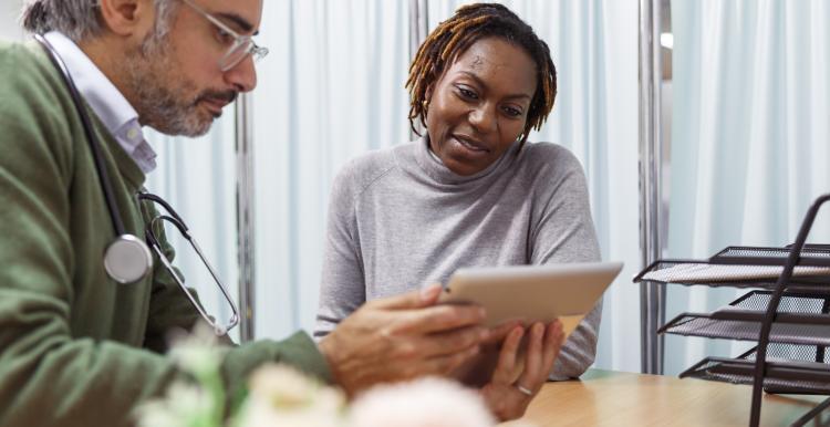 Patient sat with a GP viewing some electronic information  