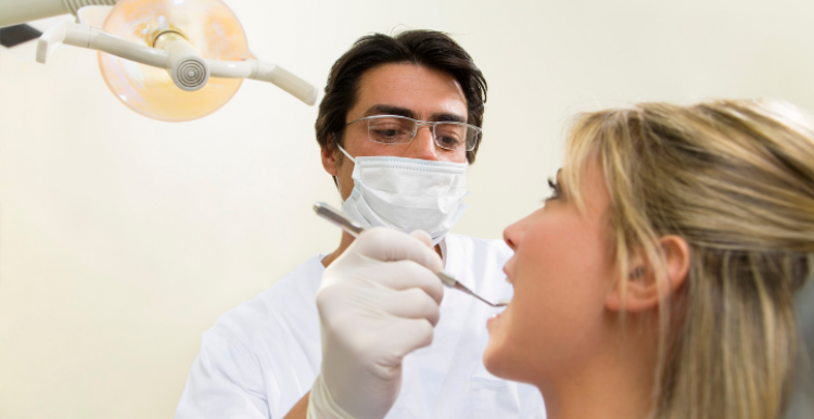dentist looking in the mouth of patient 