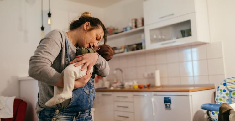 Women holding baby in her kitchen