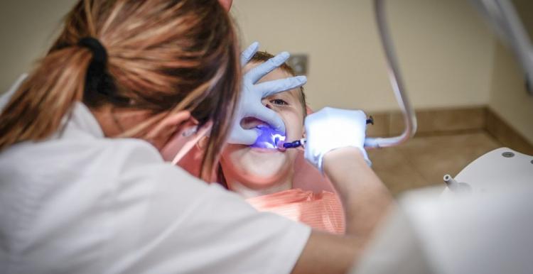 dentist looking into childs mouth 