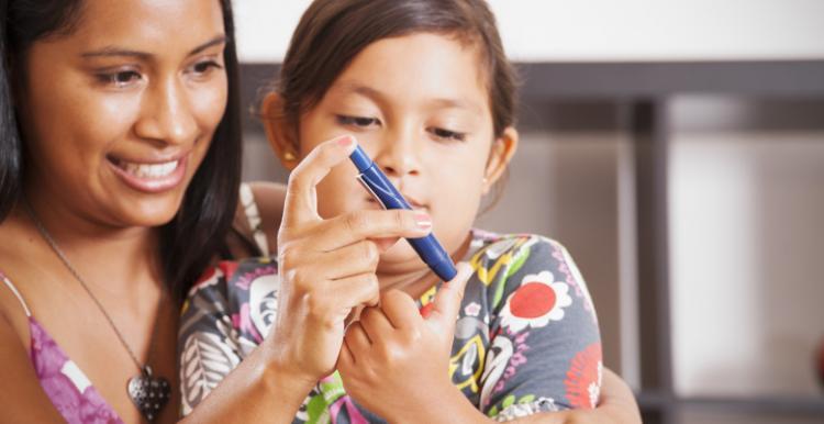 young woman and child with finger prick device 