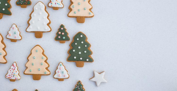 tree shaped gingerbread biscuits with white and green icing.