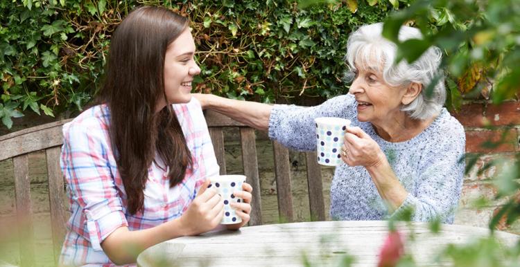 younger woman and an older woman sat outside 