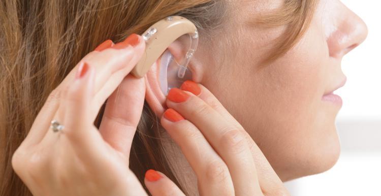 woman applying hearing aid