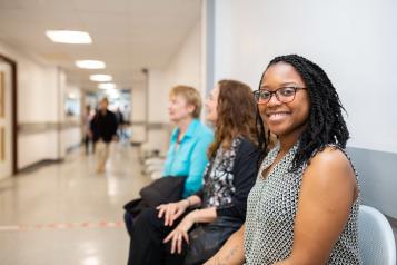 Three women sat waiting in a hospital corridor