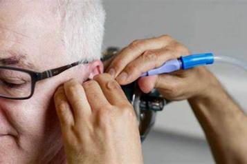 man having ear syringed