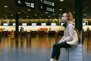 Young woman sat waiting in an airport 