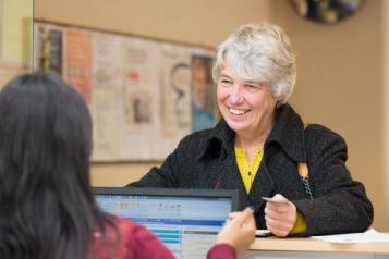 lady at a GP reception desk 