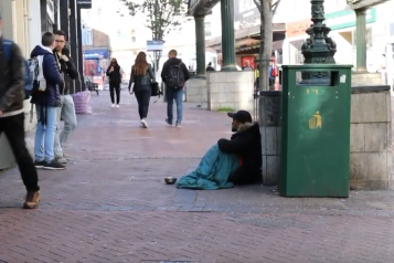 homeless man on a busy street 