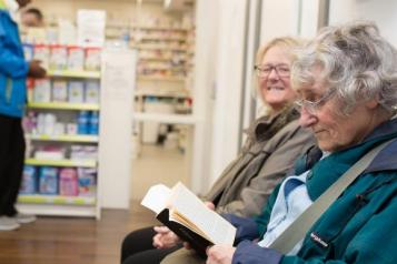 Two people sat in a pharmacy 