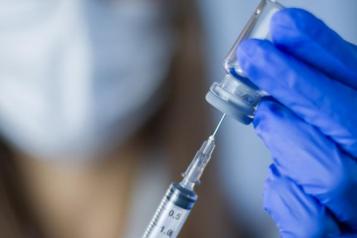 Doctor holds syringe and bottle with vaccine 