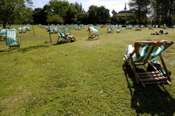 people in the sun on deckchairs 