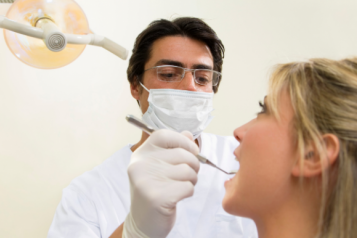 dentist looking in the mouth of patient 