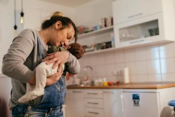 Women holding baby in her kitchen
