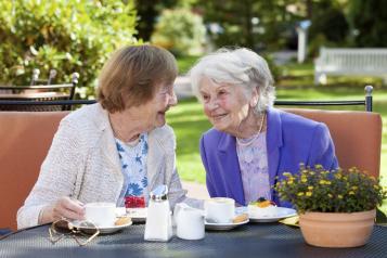 two older women sat outside talking 