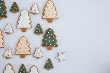 tree shaped gingerbread biscuits with white and green icing.