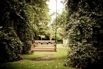 Swing bench between two bushes in a garden