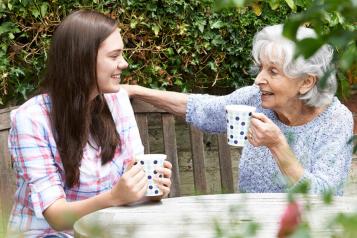 younger woman and an older woman sat outside 